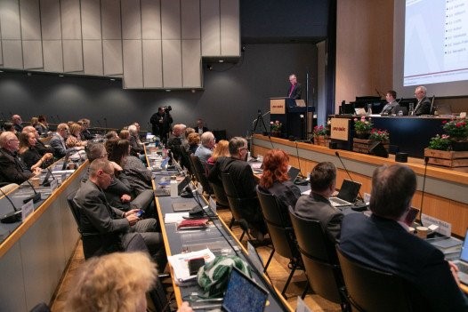 Kirkolliskokouksen edustajia salissa.
