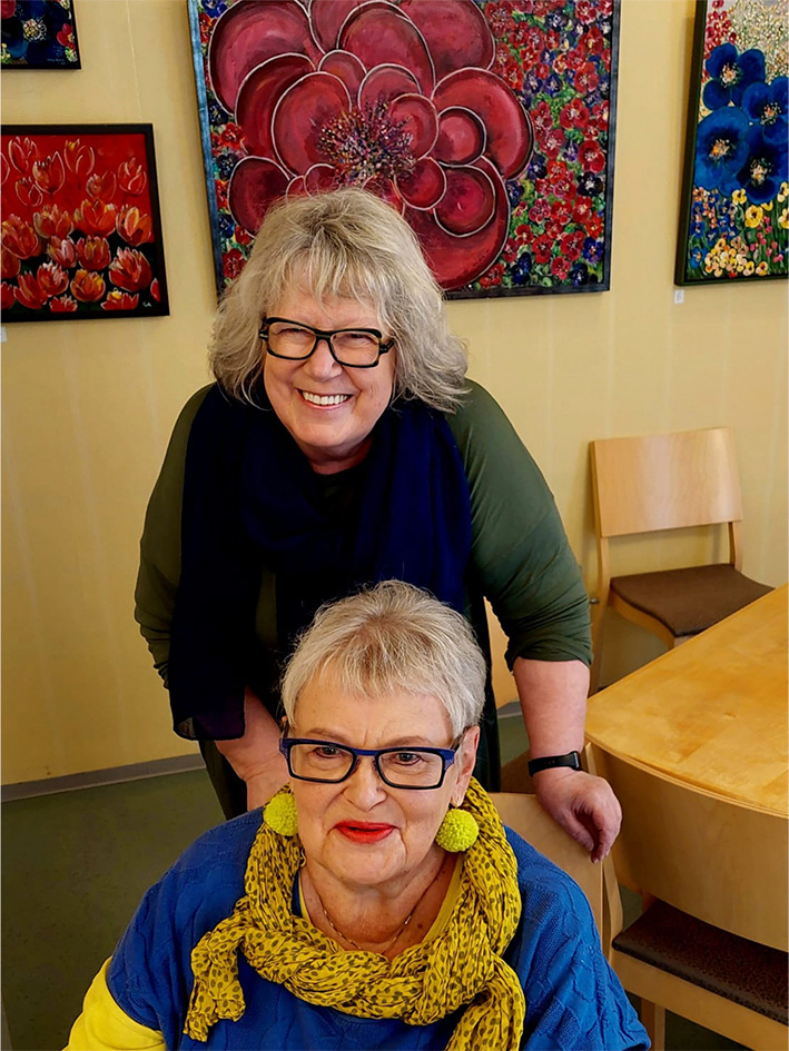 Ulla Aurio ja Mari Peltoniemi Kulmakiven kabinetissa Ullan maalausten edessä.