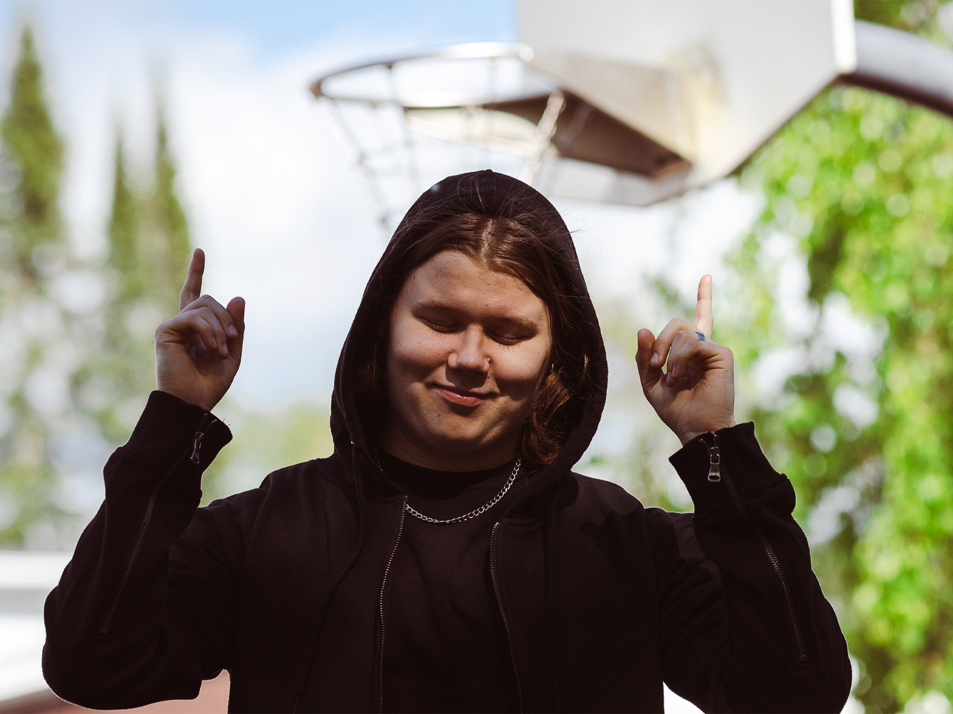 Mies osoittaen sormilla ylös päin.